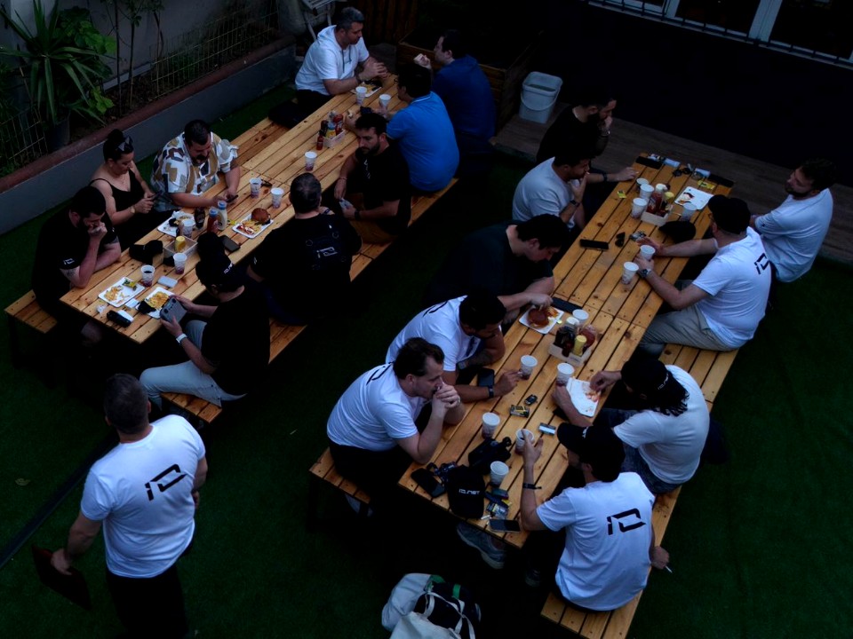 io.net Event 2025: guests at long wooden tables in the garden of the venue
